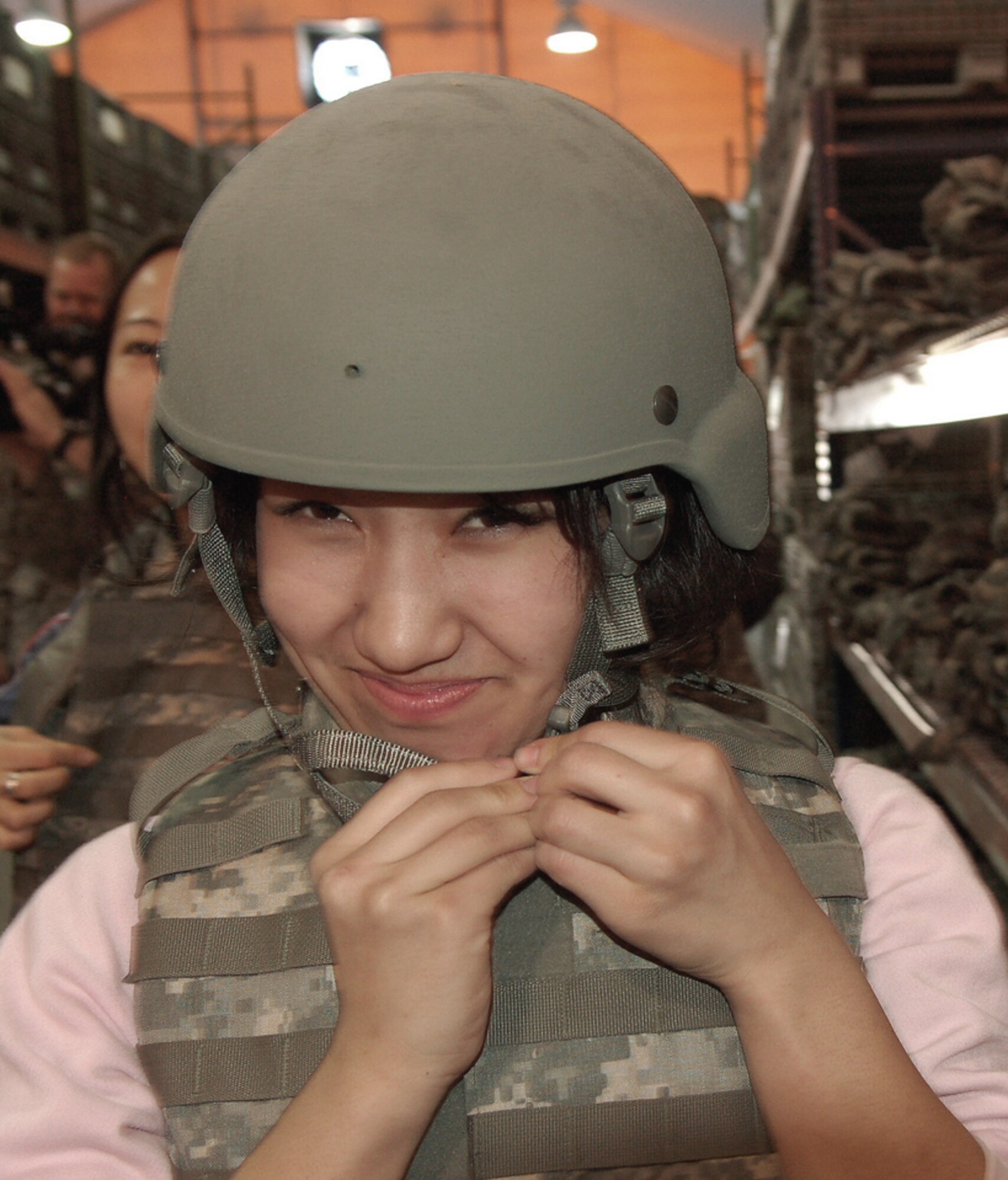 Aikanysh Atakanova grins as she takes in the 35-pound weight of individual body armor while visiting the Expeditionary Theater Distribution Center March 26 at Manas Air Base, Kyrgyzstan. Ms. Atakanova, a student at the American University of Central Asia, visited Manas AB with 12 other students and faculty for an orientation tour and dinner hosted by the 376th Air Expeditionary Wing Public Affairs office. (U.S. Air Force photo/Tech. Sgt. Phyllis Hanson) 
