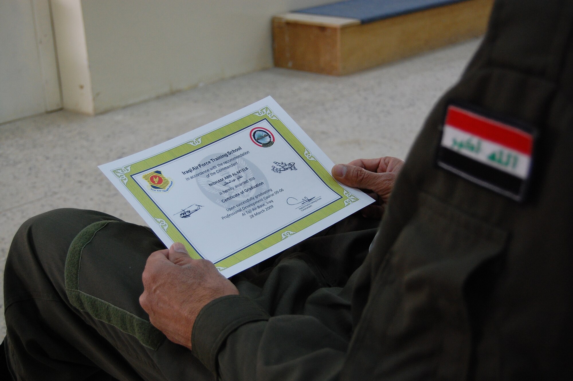 Iraqi Chief Warrant Officer Nidham Abd Al Mtleb, class leader, looks at his graduation certificate after completing the Iraqi warrant officer professional development course March 28. Twenty-nine Iraqi warrant officers completed the seven-day course where they were taught lessons on discipline, leader influence, teamwork and development, ethics and values, Law of Armed Conflict and problem solving. (U.S. Air Force photo by Staff Sgt. Tim Beckham)