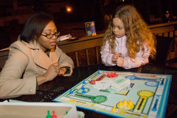 HANSCOM AIR FORCE BASE, Mass. –Airman First Class Latoya Walker joins Isis Shrader in playing a board game during the Earth Hour event on March 28. Hanscom’s dormitory residents invited the base community to join them and millions of people around the world in doing their part to affect climate change by turning off electricity for one hour. The event was held outside of the dormitory building where participants brought flashlights and enjoyed games and events outside as well as discussions about energy conservation.  (U.S. Air Force photo by Linda LaBonte Britt)