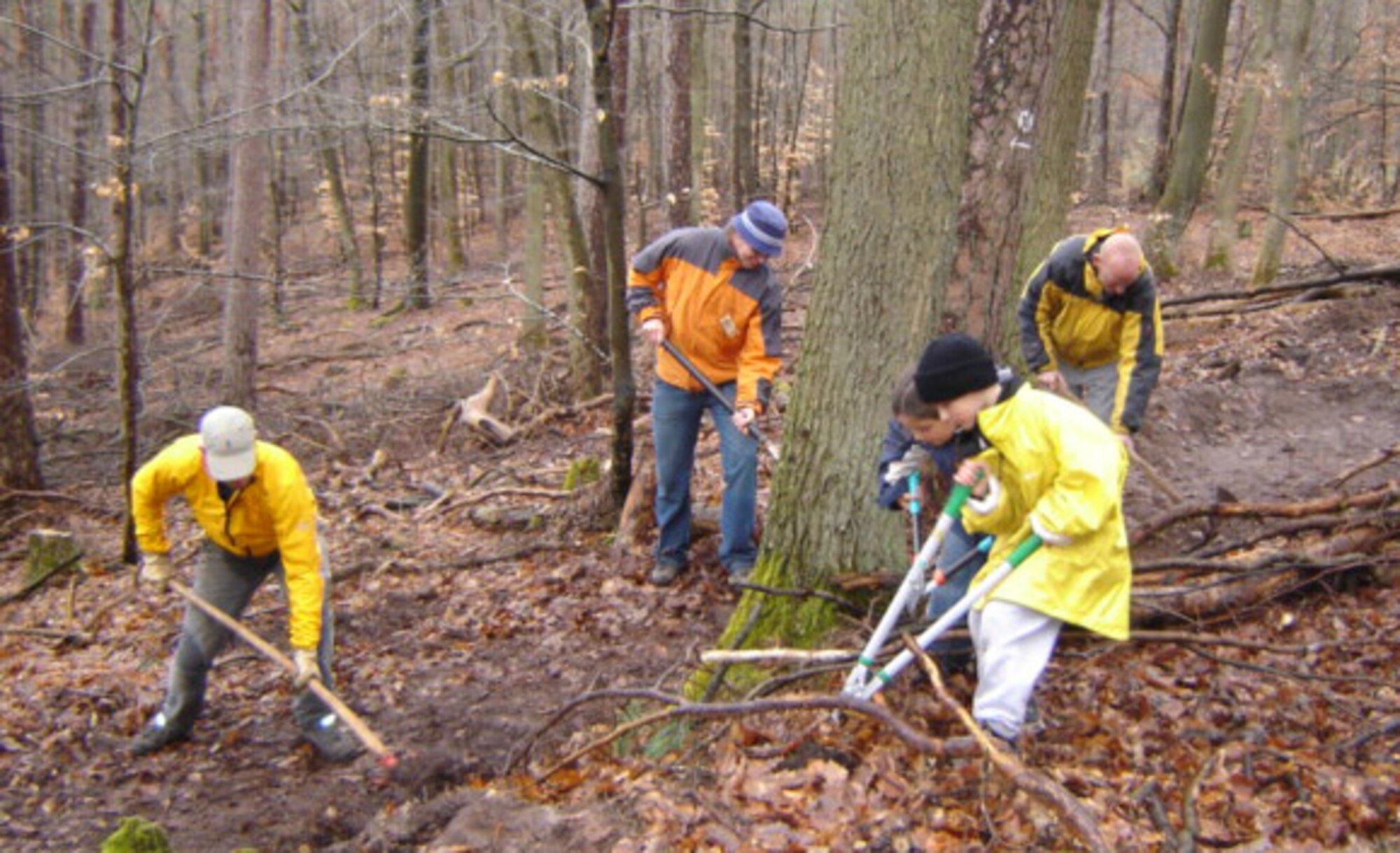 WEIDENTHAL, Germany – Volunteers work together to remove brush and logs from an over-grown trail in the village of Weidenthal March 28, 2009. Despite the rainy weather the Saber Cycling Club, Ramstein Area Cycling Club and villagers were able to clear the previously abandoned section of trail for cyclists, hikers and equestrians. (Courtesy photo)