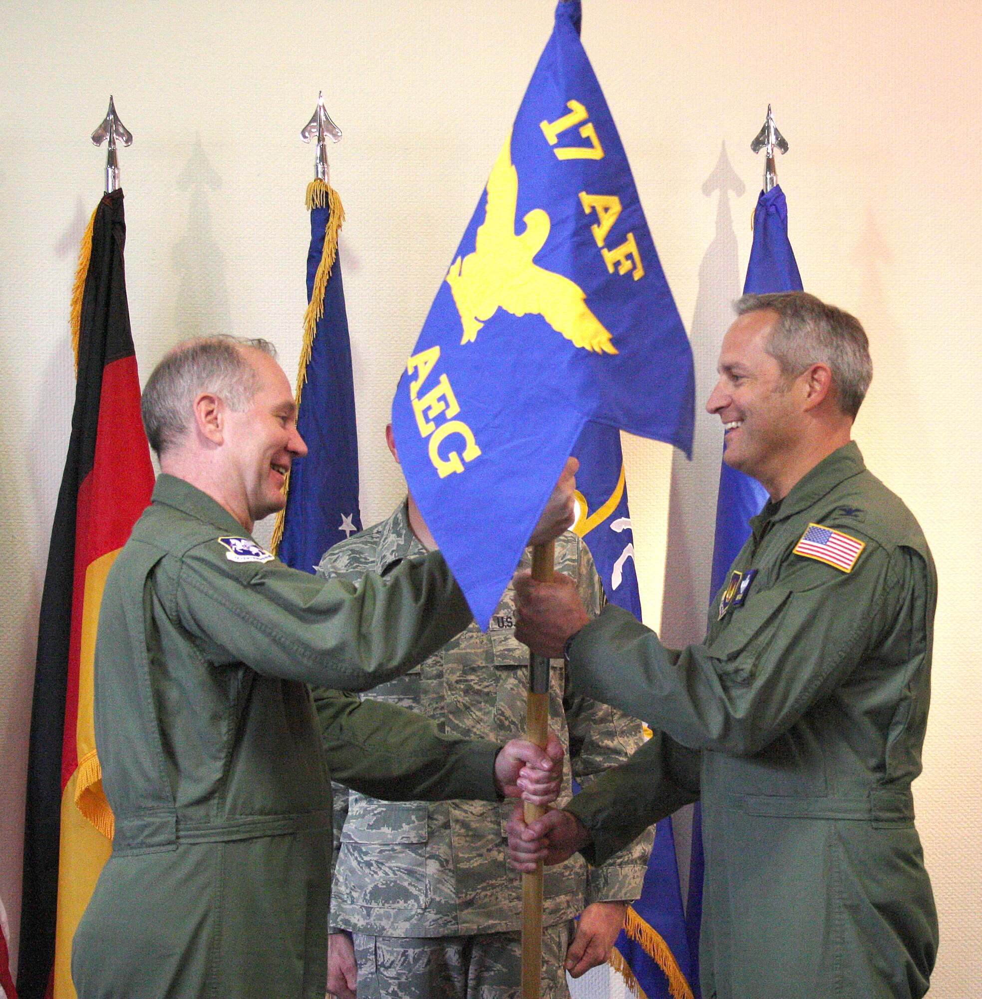Maj. Gen. Ron Ladnier (left), Commander of 17th Air Force (Air Forces Africa), passes the 404th Air Expeditionary Group flag to new commander Col. Mark D. Vijums during a change of command ceremony here March 24. Vijums comes to the 404th as an Air Force Reservist who also serves as the vice commander, 934th Airlift Wing at Minneapolis-St. Paul International Airport under Air Reserve Command. He replaces outgoing 404th CC Col. Lida Dahnke, who commanded the unit since its October 2008 standup. Also an Air Force Reservist, Colonel Dahnke returns to Hurlburt Field, Fla., where she is assigned to Air Force Special Operations Command. 
The 404th oversees flying operations for AFAfrica, including Ramstein's 42nd Expeditionary Airlift Squadron. The Group recently orchestrated airlift assistance to Rwandan peacekeepers in the Darfur region of Sudan. Assisting in the transfer of command is 17th AF Command Chief Chief Master Sgt. Timothy Steffen (behind flag). (USAF Photo by Master Sgt. Dave McClelland) 