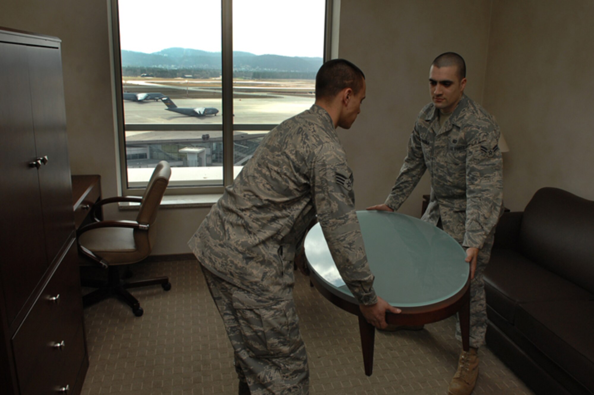 Senior Airman Christopher Gonzalez and Airman 1st Class Cory Prochaska, both from the 435th Services Squadron, deliver furniture to the new visitor quarters at the Kaiserslautern Military Community Center on Ramstein Air Base. The eight-story, 350-room visiting quarters facility will be one of the first areas to open as part of a $170 million project that will offer approximately 844,000 square feet of lodging, shopping and entertainment under one roof. (U.S. Air Force photo by Airman 1st Class Tony Ritter)
