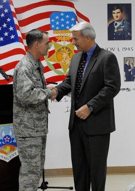 SOUTHWEST ASIA -- Brig. Gen. H.D. Polumbo Jr., 380th Air Expeditionary Wing commander presents Maj. Jim Hedges (Ret.), a local contractor and instructor of the chapel's "Bible in the Middle East" lecture series, with a small token of gratitude for his participation in the 380th AEW annual National Prayer Breakfast. More than 70 Airmen gathered together in fellowship for the breakfast here April 1. (U.S. Air Force photo by Staff Sgt. Mike Andriacco) (Released)