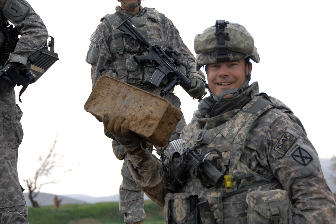 U.S. Army 1st Sgt. Michael Sadowski, works with a provincial mentorship team to find a weapons cache in a dirt wall bordering Baraki Barak in the Logar province, Afghanistan March 26, 2009.