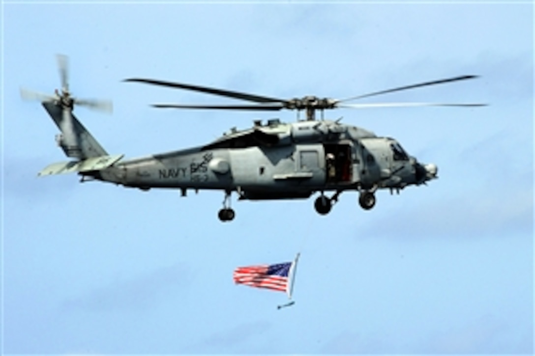 An SH-60H Sea Hawk helicopter parades the colors above the flight deck during an air power rehearsal held over the USS Theodore Roosevelt in the Mediterranean Sea, March 30, 2009. The aircraft carrier is operating in the 6th Fleet area of responsibility.
