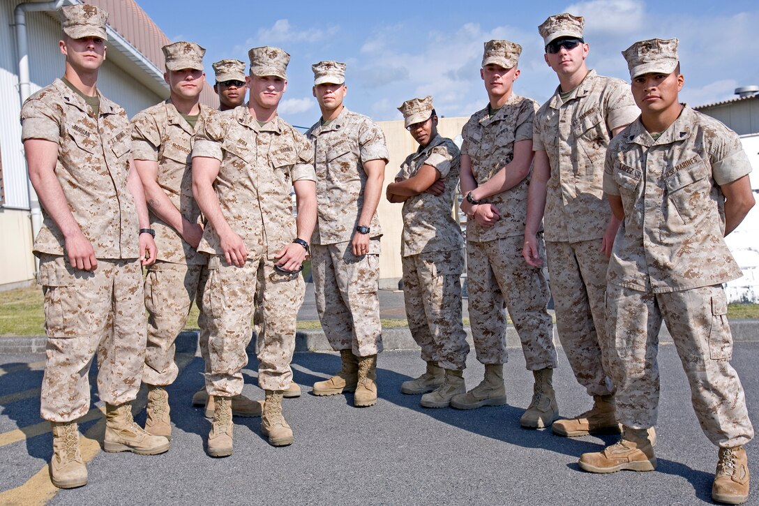 From left to right, Cpl. Bryan Morgan, Lance Cpl. Justin McDougall, Cpl. Neilon Baptiste, Cpl. Brian Reda, Sgt. Eric Duran, Cpl. Tara Highbaugh, Cpl. John Hildebrant, Lance Cpl. Kevin Bett and Cpl. Sergio Lopez of Combat Logistics Company 36 strike a triumphant pose here April 1 after the breakfast welcoming them home from their nearly year-long tour in Iraq. During their tour, most of the Marines got their first, long field environment experience and were able to bask in the joy of working long hours, adjusting to the climate, going long spans of time without bathing and disposing of their own bodily waste.