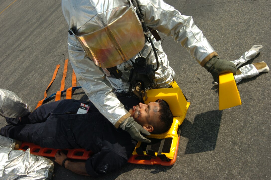 A Station Aircraft Rescue Firefighter works feverishly to save a mock victim during the mass casualty exercise here April 1. The mass casualty excercise was a test of emergency services aboard station in preparation for Friendship Day 2009.