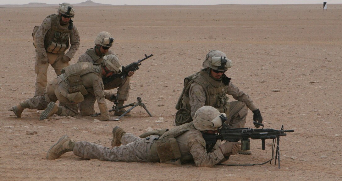 Private First Class Chad McHugh(front) and Cpl Carlos Gonzalez (rear), both from Regimental Combat Team 8's Mobile Security Detachment, watch closely as Marines of Multinational Force West's Quick Reaction Force practice assembly and target engagement during a weapons training exercise April 2, 2009.  The QRF Marines are originally from Bravo Company, 1st Tank Battalion Regimental Combat Team 8.