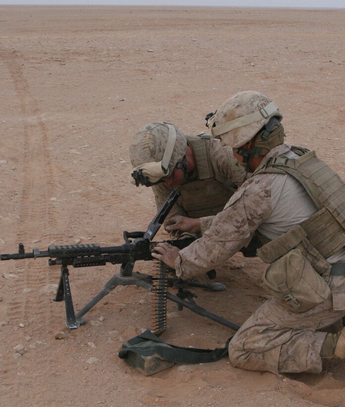 Marines from the Quick Reaction Force stationed at Al Asad Airbase reload an M240 Bravo machinegun during a weapons training exercise, April 2, 2009.  The wepons training focused on proper target engagement, and night fire with the M240 as well as the M249 squad automatic weapon.