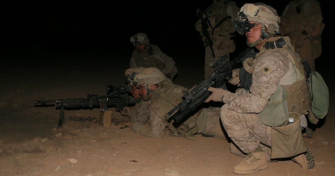 Staff Sgt Ysidro Gonzalez, a platoon sergeant with Regimental Combat Team 8's Mobile Security Detachment, eyes targets down range as a machinegun team from the Quick Reaction Force engage targets during a night-fire exercise April 2, 2009.  Gonzalez was the lead instructor during the wepons traning for the QRF.  (U.S. Marine Corps photo by Cpl Alan Addison)