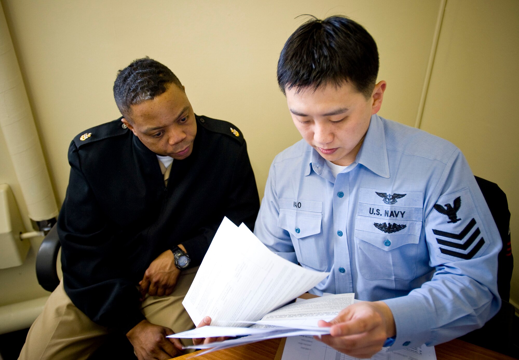MISAWA AIR BASE, Japan -- Navy Petty Officer 1st Class Mike Kao (right) reviews tax documents with Senior Chief Petty Officer Andrew Washington at the Misawa Air Base Tax Center April 2, 2009. This is Petty Officer Kao's second year volunteering at the Misawa Air Base Tax Center and eighth year helping his fellow shipmates with their taxes. (U.S. Air Force photo by Staff Sgt. Samuel Morse)