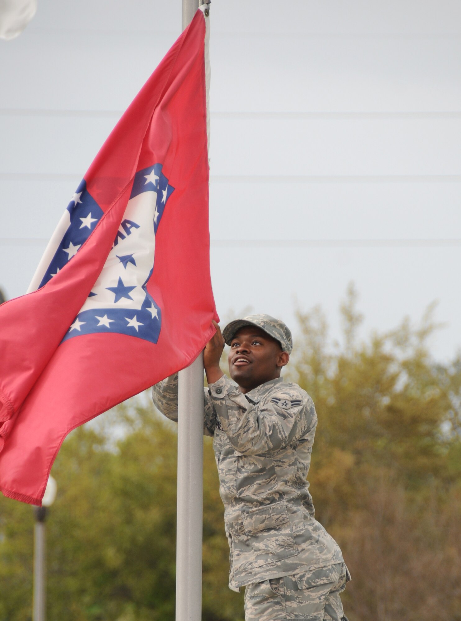 Airman 1st Class Larico Brownlee, 81st Logistics Readiness Squadron, hangs the Arkansas state flag along the Larcher Avenue of Flags March 24.  He was assisting members of Keesler 5/6 in replacing all state flags, a twice-yearly undertaking.  (U.S. Air Force photo by Kemberly Groue)