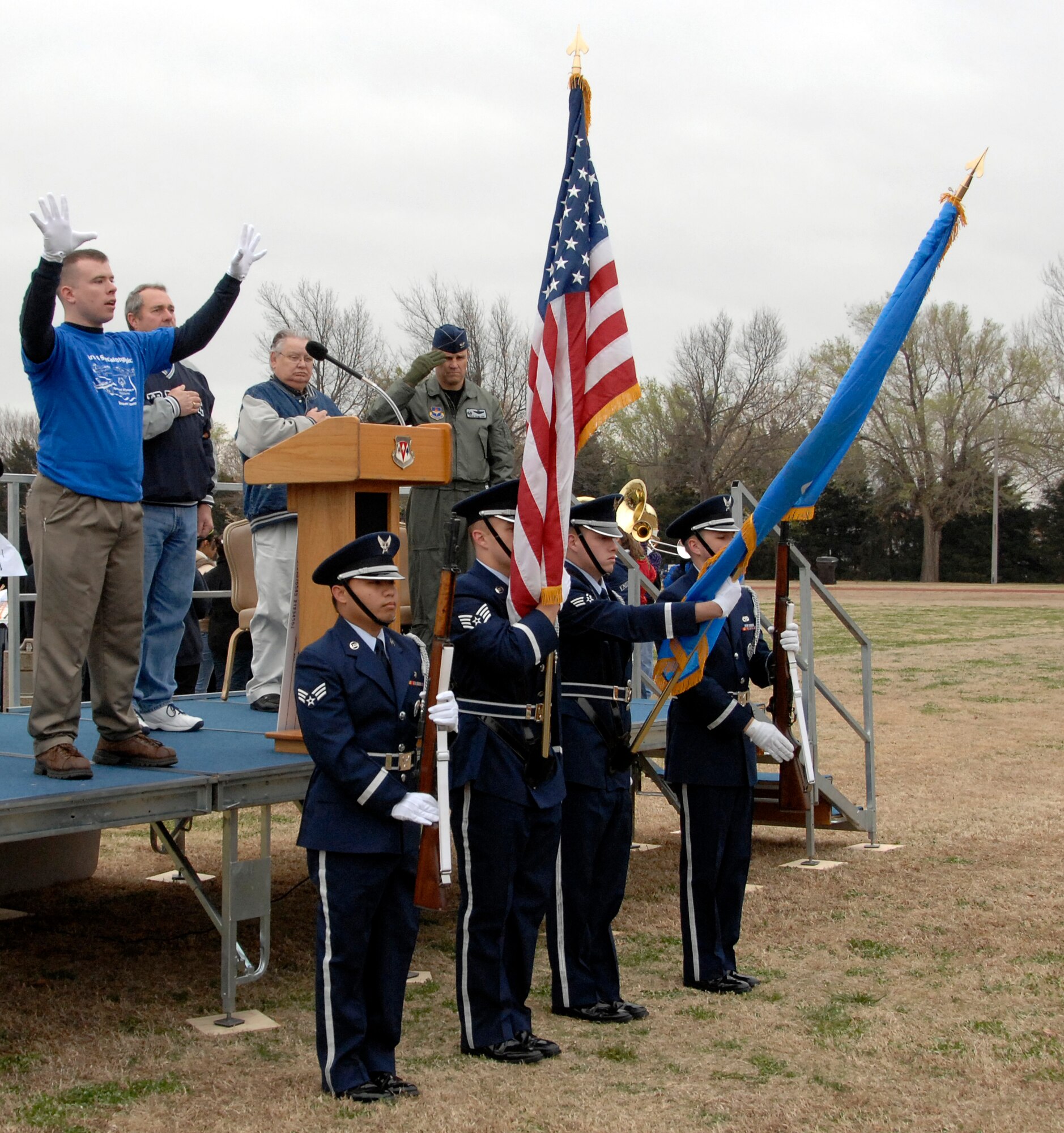 Airman 1st Class Benjamin Ekblad, left with white gloves, performs the national anthem in sign language while the Vance Silver Talon Honor Guard presents the colors during opening ceremonies for the 2009 Cherokee Strip Area 6 Track and Field Athletics meet, also known as the Area 6 Special Olympics, held at Vance March 26. More than 250 Vance Airmen volunteered to assist the 225 athletes compete in 13 events. In the 40-year history of the Area 6 Special Olympics, 20 of the competitions have been held at Vance. (U.S. Air Force photo by Terry Wasson)