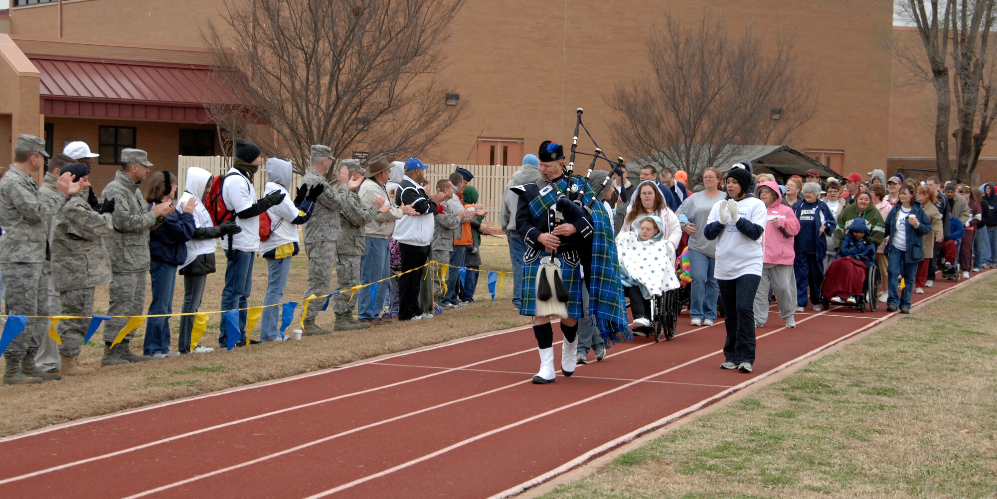 Chaplain (Lt. Col.) Michael Gilbert, 71st Flying Training Wing chaplain, leads the athletes participating in the 2009 Cherokee Strip Area 6 Special Olympics, as they parade around the running track at Vance March 26. Chaplain Gilbert played “Scotland the Brave” on the bagpipe. More than 250 Vance Airmen volunteered to assist 225 athletes competing in 13 events. Qualifying athletes will compete at the state-level Special Olympics in Stillwater, Okla., in May. (U.S. Air Force photo by Terry Wasson)