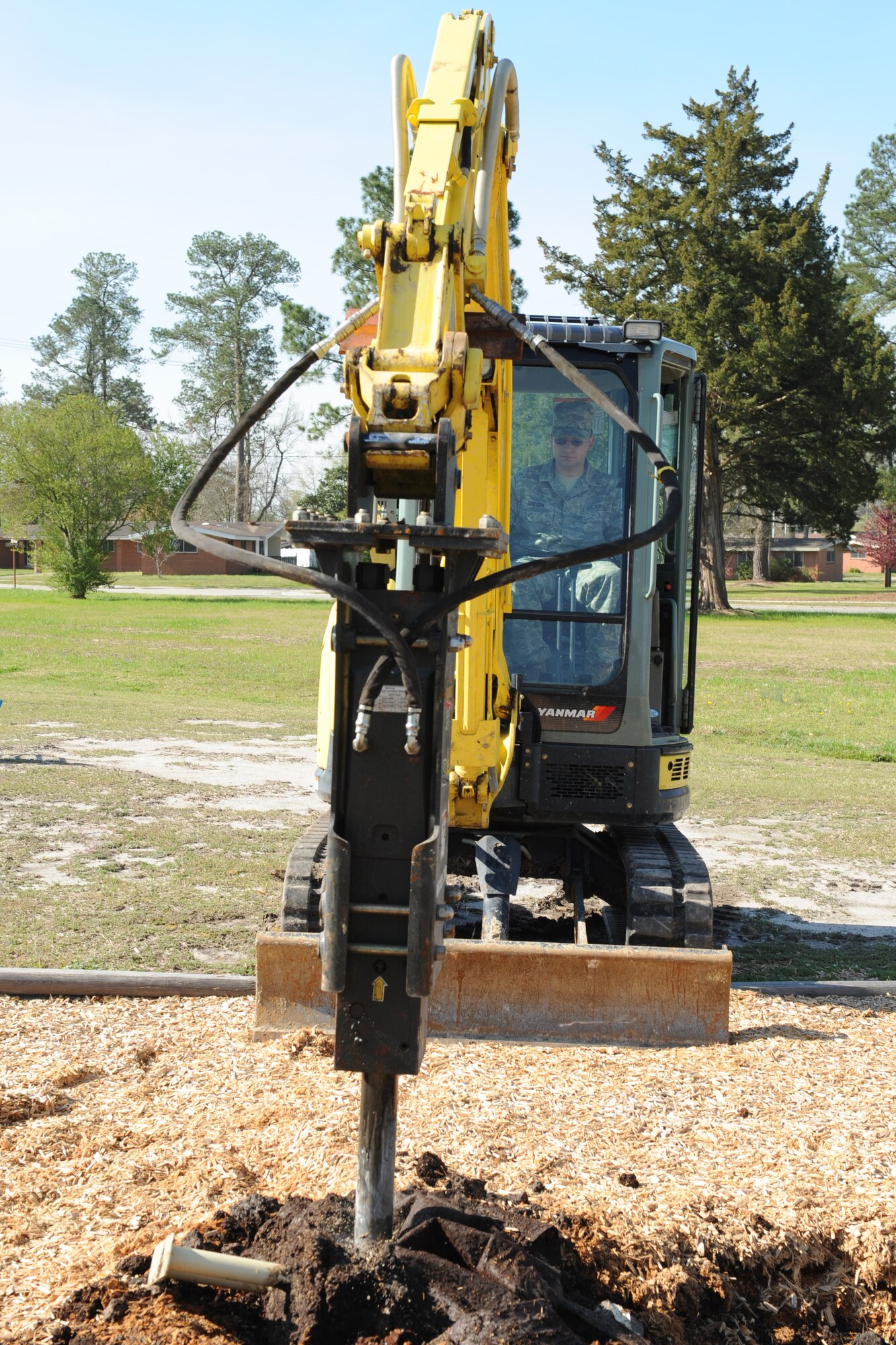 Airman 1st Class Phil Gregor, 4th Civil Engineer Squadron, helps tear down a base playground by using a mini-excavator on Seymour Johnson Air Force Base, N.C., March 31, 2009. The mini-excavator is a hydraulic hammer that is used to bust the concrete. 4th CES Heavy Equipment members drill and fill concrete where it's needed on base.  (U.S. Air Force photo by Airman 1st Class Whitney S. Lambert)  