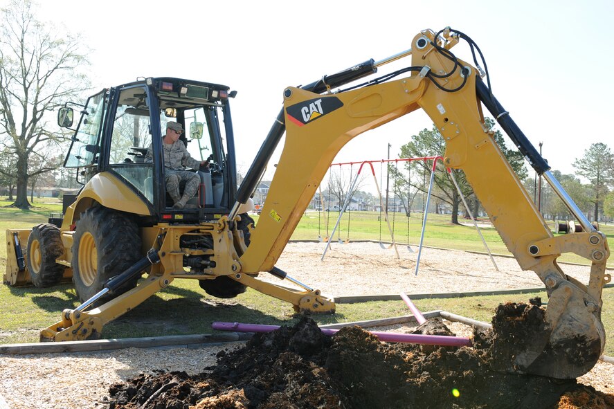Staff Sgt. Kenneth Carter, 4th Civil Engineer Squadron, operates a backhoe in base housing at Seymour Johnson Air Force Base, N.C., March 31, 2009. Sergeant Carter is removing the foundation from a playground which will be donated to Meadow Lane Elementary School in Goldsboro, N.C. 4th CES Heavy Equipment Airmen do many jobs on the base such as construction and demolition of buildings here.  (U.S. Air Force photo by Airman 1st Class Whitney S. Lambert)  
