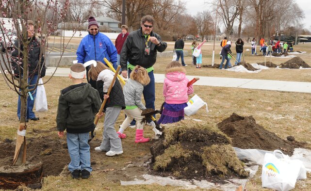 Kids from the Youth center plants new trees behind Fairchild’s white house building. The event culminated the Arbor Day celebration at the Deel community center. (U.S. Air Force photo / Staff Sgt JT May III)