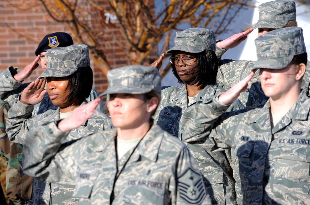 A group of female Airmen salute during a retreat ceremony, March 27. The Airmen represent servicewomen, past and present, in the U.S. military. Women's History Month is celebrated in March to increase consciousness and knowledge of the contributions made by women. (U.S. Air Force photo/Senior Airman Marc I. Lane)
