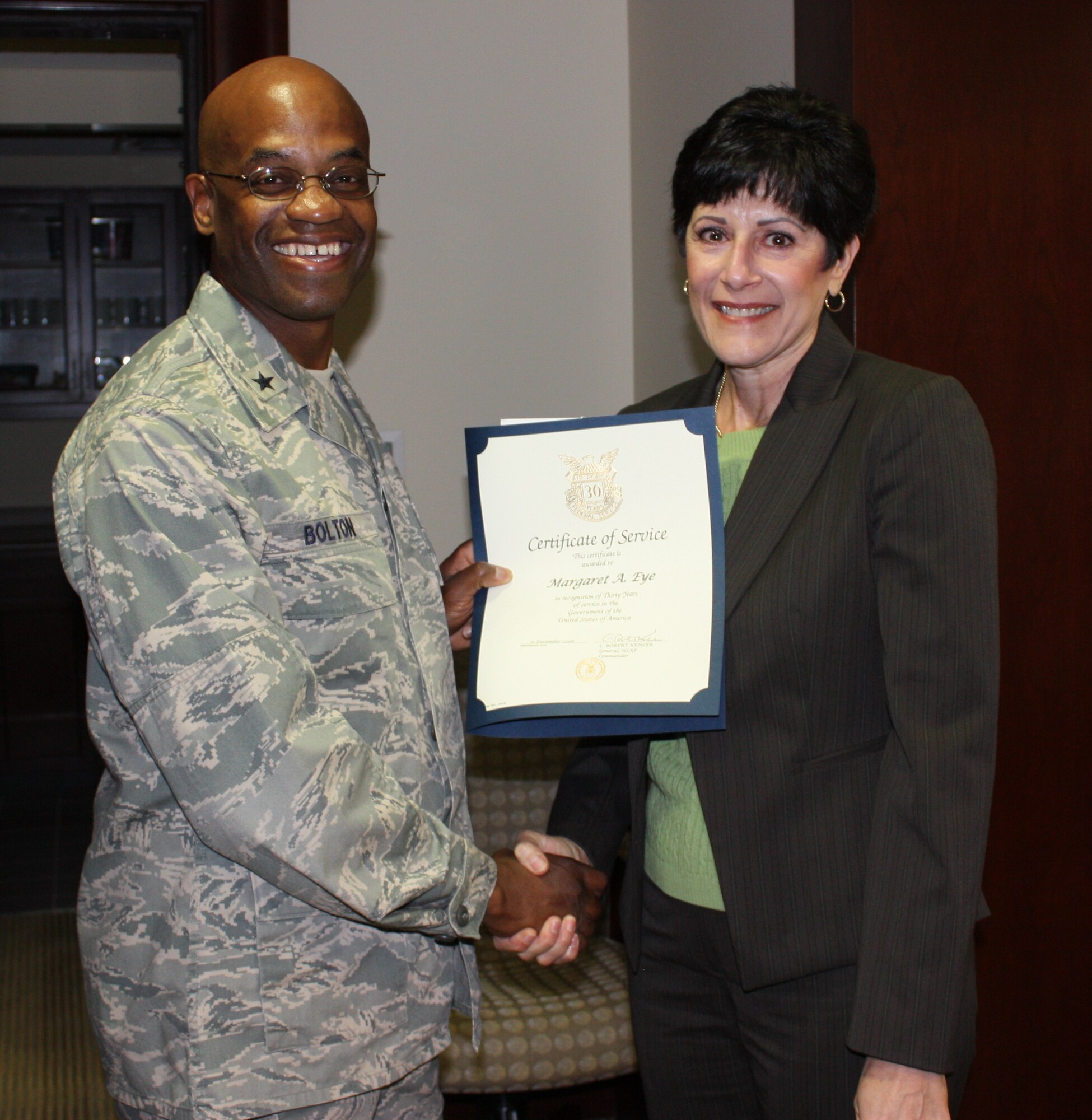 Margaret "Peggy" Eye is presented with a certificate recognizing 30 years of civil service work by 45th Space Wing Commander Brig. Gen. Edward L. Bolton Jr. April 2 in the Wing conference room. (U.S. Air Force photo/Airman 1st Class David Dobrydney)