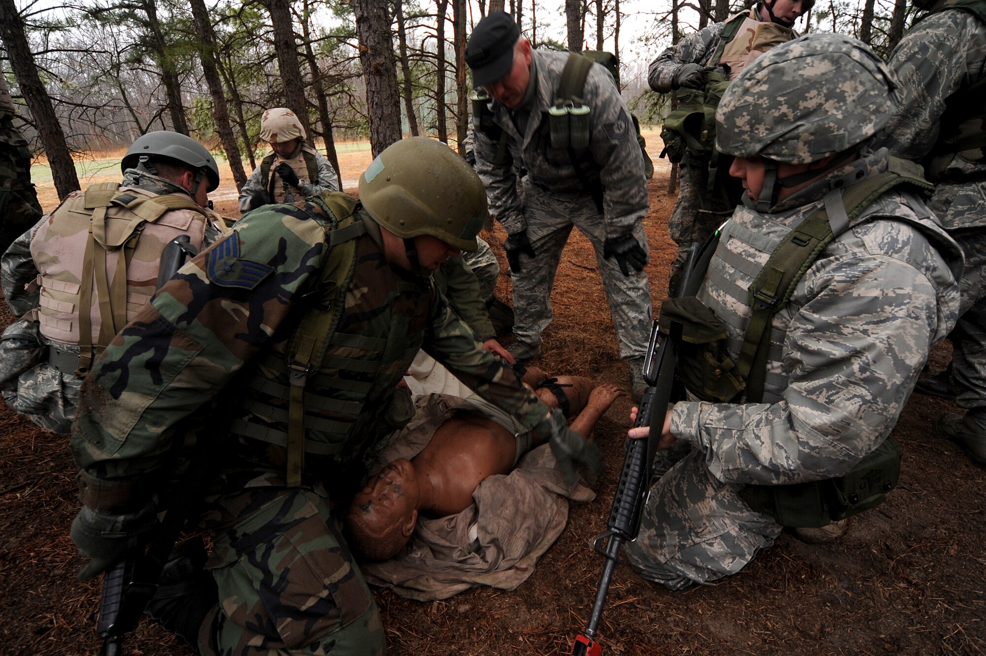 Airmen perform combat first aid on a simulated casualty victim during a training scenario on a Fort Dix, N.J. range, March 26, 2009.  The students are in a U.S. Air Force Expeditionary Center's Advanced Contingency Skills Training Course taught by the 421st Combat Training Squadron which prepares Airmen for upcoming deployments with advanced combat skills.   (U.S. Air Force Photo/Staff Sgt. Nathan G. Bevier) 