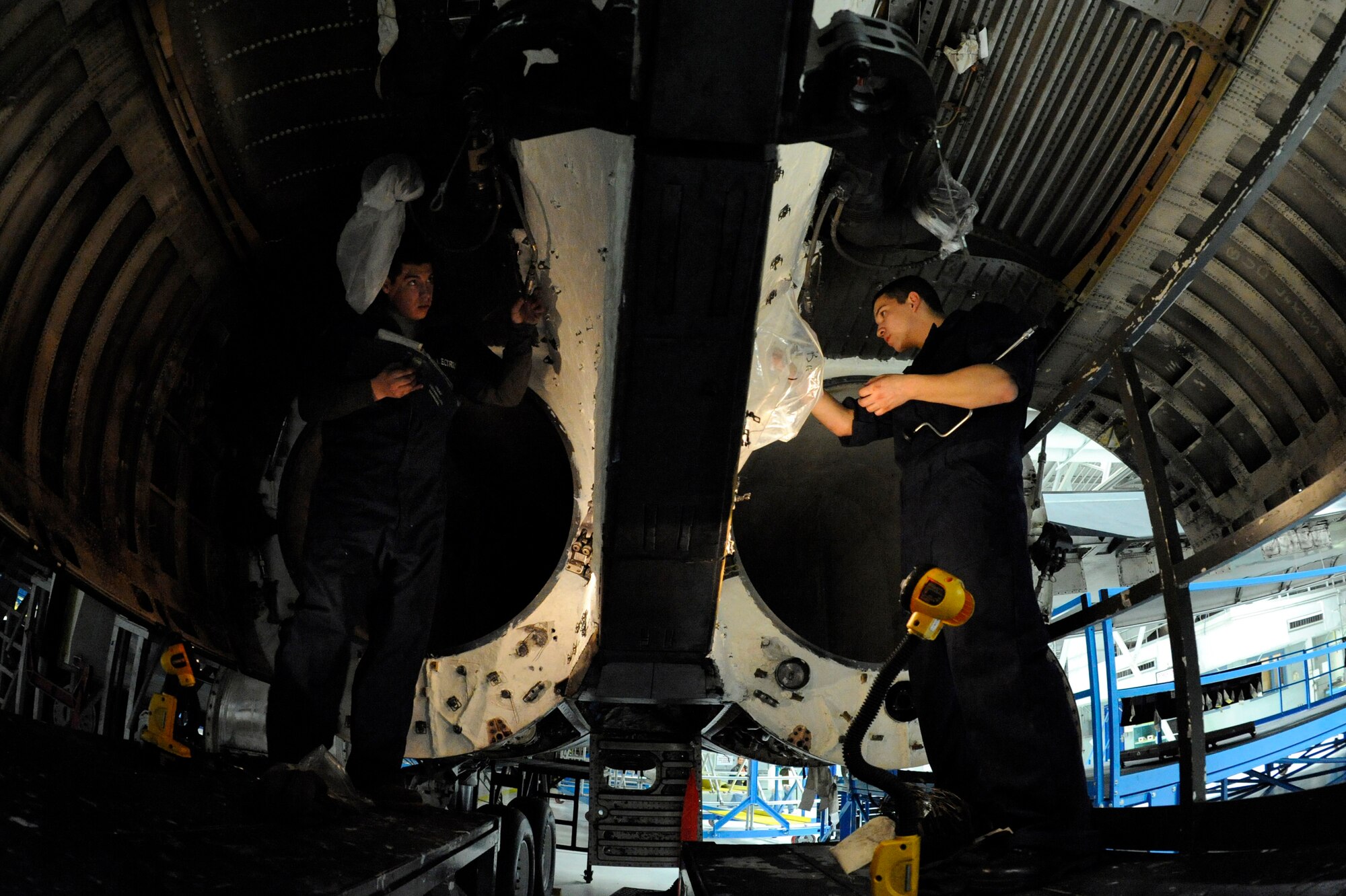 (left) Senior Airmen Efstathiou Kostantinos and Isaiah Beltran, 28th Maintenance Squadron electrical and environmental technicians, install fire loops in the engine bays of a B-1B Lancer here, April 1. Fire loops are used to detect fires in the engine bay. (U.S. Air Force photo/Airman 1st Class Matthew Flynn)