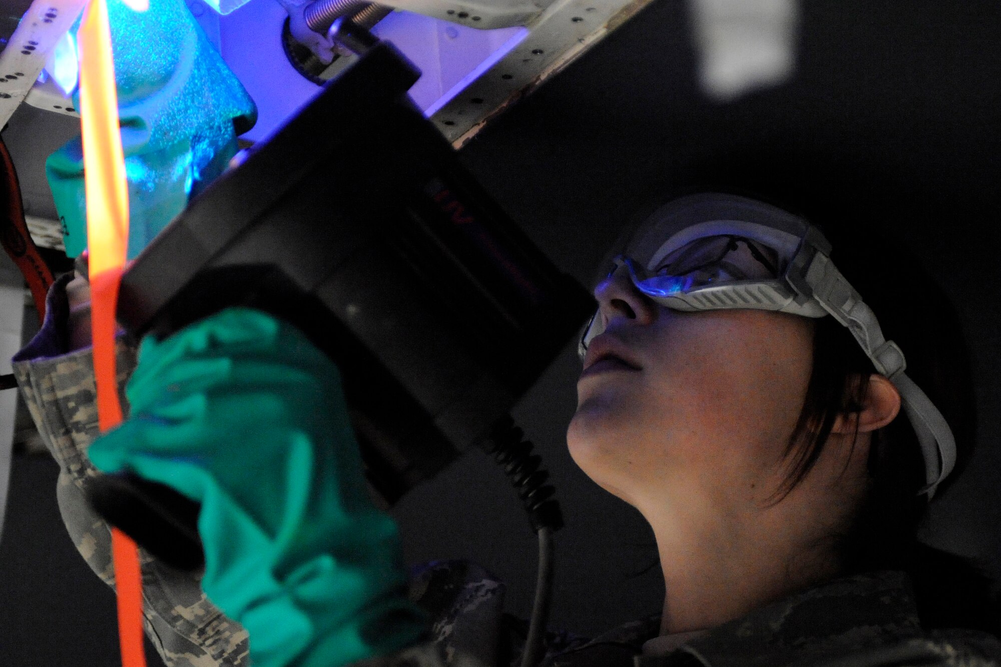 Senior Airman Jennifer Wolfe, 28th Maintenance Squadron non-destructive inspector, uses a black light to aid in detecting cracks in the number two slat of a B-1B Lancer here, April 1. Airman Wolfe used a fluorescent penetrating spray to make any possible cracks visible under black light. (U.S. Air Force photo/Airman 1st Class Matthew Flynn)