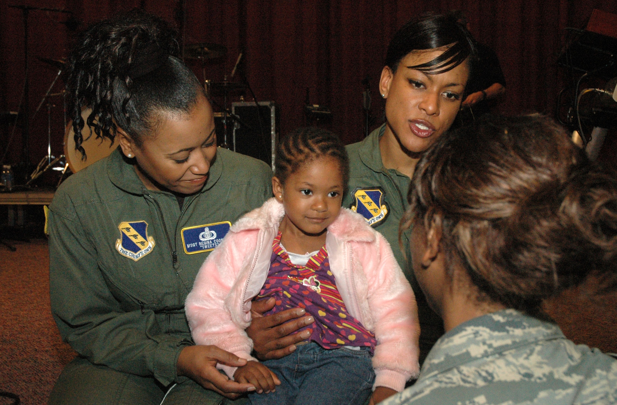 Master Sgts. Regina Coonrod and Shani Prewitt, members from the United States Air Force Band’s premier rock group, talk to Airman 1st Class Fatimah Shareef-Malik and her four year-old daughter Lailah, March 27 after a Max Impact performance at Robin Air Force Base, Ga. (U.S. Air Force photo by Senior Airman R. Michael Longoria)