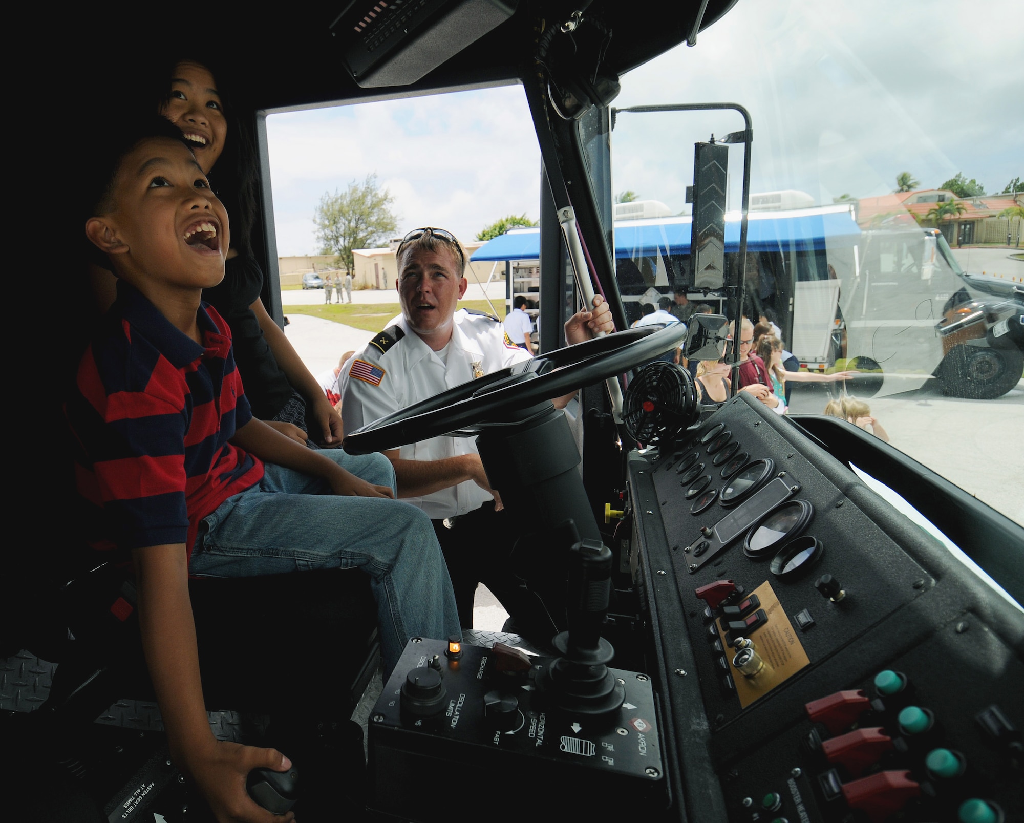 Will O'Meara shows children the functions of a fire engine during the March 28 open house at the Andersen Air Force Base, Guam. The event showcased the fire unit, explosive ordnance disposal unit, a K-9 unit, a KC-135 Stratotanker, an F-22 Raptor, and a B-2 Spirit. Mr. O'Meara is the Andersen AFB Fire and Emergency Services Flight station chief. (U.S. Air Force photo/Airman 1st Class Courtney Witt) 
