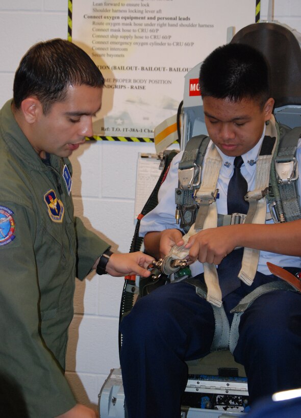 Airman 1st Class Alejandro Ruiz, 82nd Aerospace Medicine Squadron, assists Al-Jazer Jakaria, Wylie High School Air Force Junior ROTC cadet, into a T-38 seat.  Aerospace physiology was one of several stops 81 cadets enjoyed during their tour of Sheppard March 31 and April 1. (U.S. Air Force photo/Mike McKito)