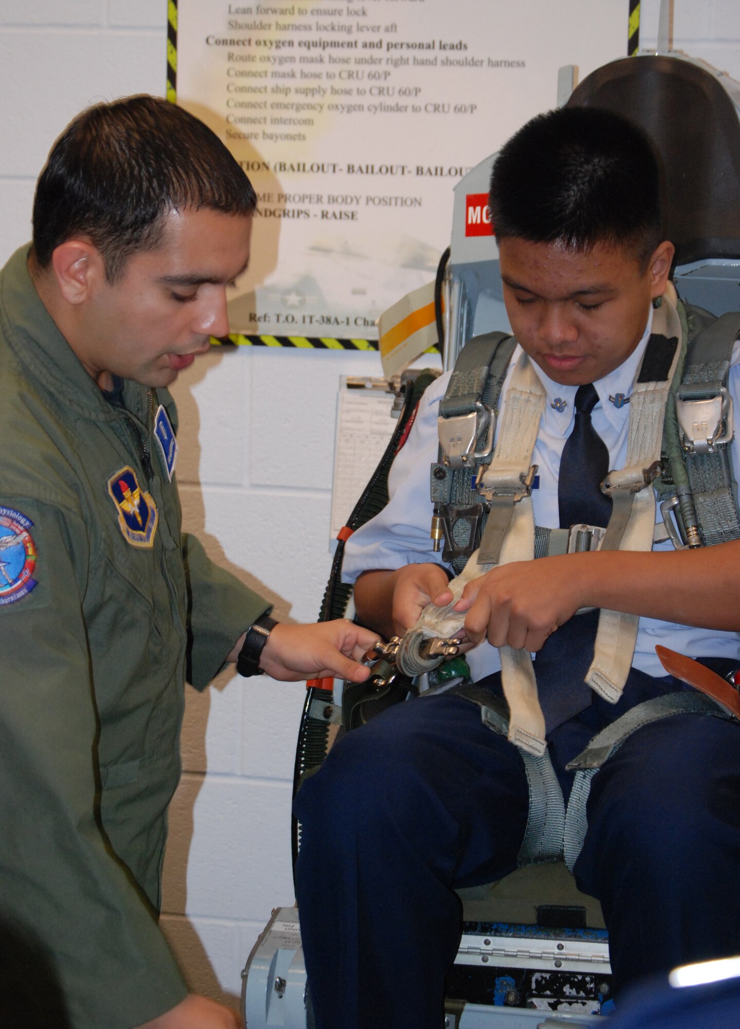 Airman 1st Class Alejandro Ruiz, 82nd Aerospace Medicine Squadron, assists Al-Jazer Jakaria, Wylie High School Air Force Junior ROTC cadet, into a T-38 seat.  Aerospace physiology was one of several stops 81 cadets enjoyed during their tour of Sheppard March 31 and April 1. (U.S. Air Force photo/Mike McKito)
