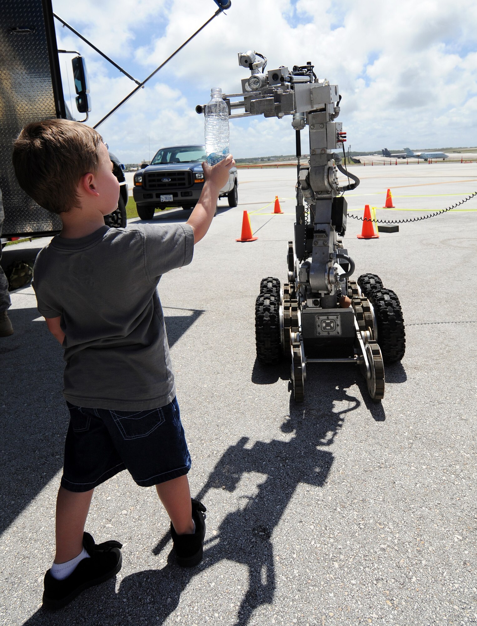 Dylan Hart is shown how the functions of a F6-Alpha explosive ordnance robot work during the March 28 open house at the Andersen Air Force Base, Guam. The explosive ordnance disposal unit also featured the EOD-9 bombsuit and the new chemical warfare suit. (U.S. Air Force photo/Airman 1st Class Courtney Witt) 
