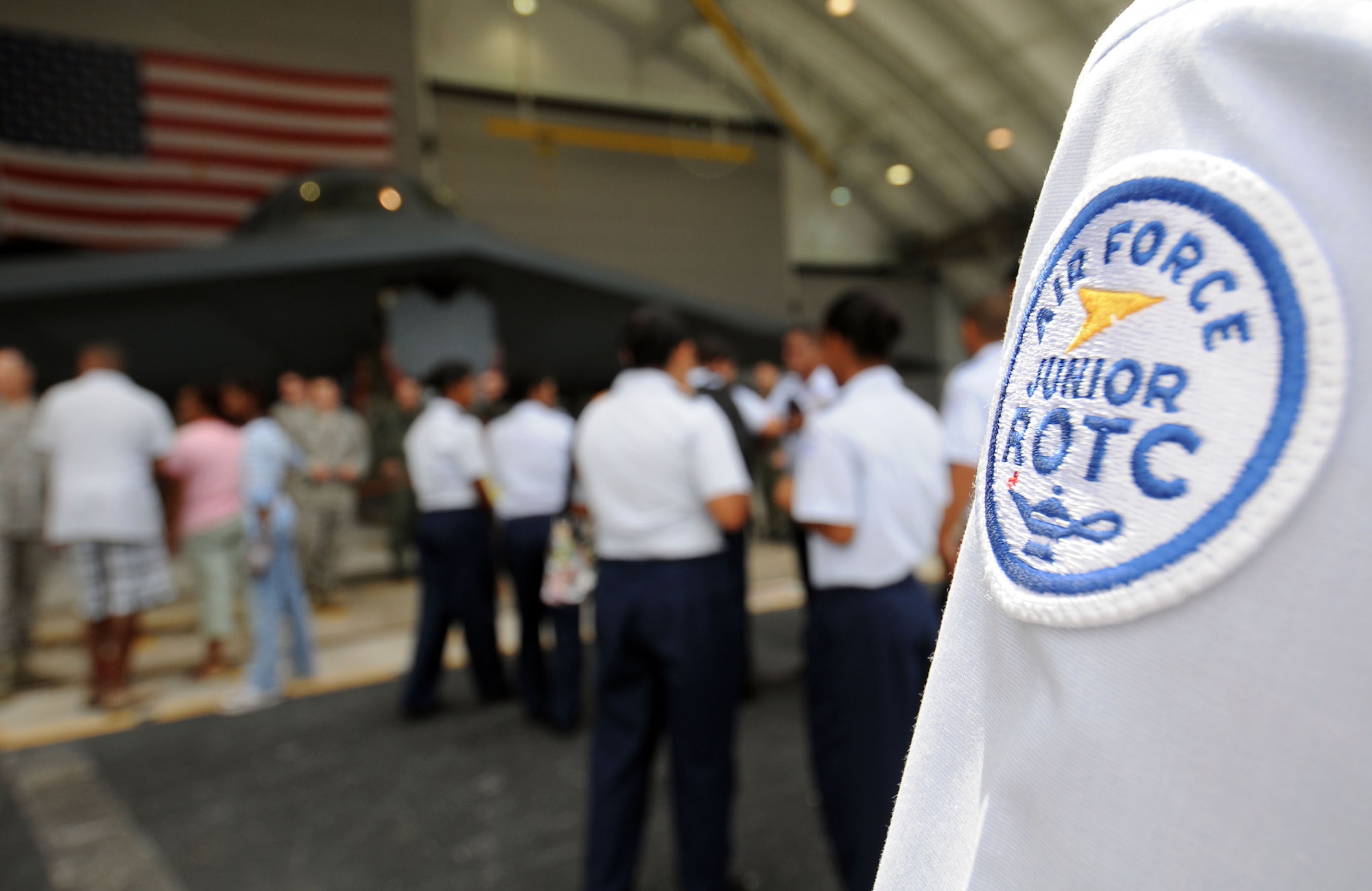 John F. Kennedy's Air Force Junior ROTC students gather around the B-2 Spirit on display for a quick photo and a brief description of the aircraft during the March 28 open house at the Andersen Air Force Base, Guam. More than 45 junior ROTC members came out to the base to receive a firsthand look at some of the Air Force's premier aircraft. (U.S. Air Force photo/Airman 1st Class Courtney Witt) 
