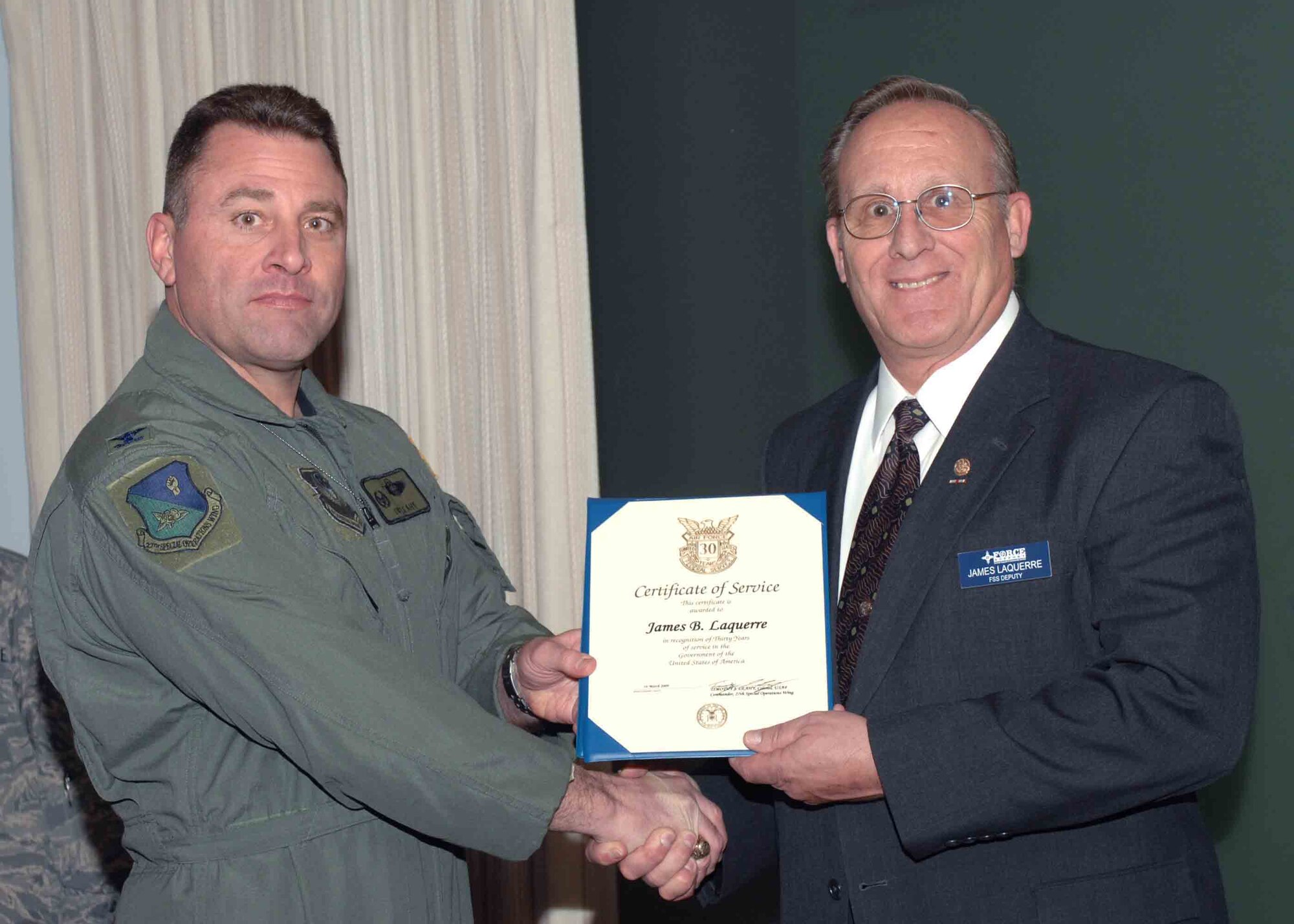 CANNON AIR FORCE BASE, N.M. -- Mr. James LaQuerre, 27th Special Operations Force Support Squadron, receives the 30-Year Service Award presented by Col. Timothy Leahy, 27th Special Operations Wing commander.  Mr. LaQuerre received the award at the weekly wing staff meeting on March 31.  (U.S. Air Force Photo/ Airman 1st Class James Bell)