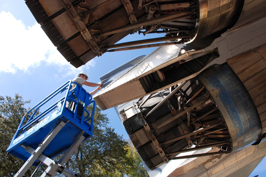 EGLIN AIR FORCE BASE, Fla. -- Staff Sgt. Kyle Sichting, 33rd Maintenance Squadron, pulls masking tape off the vertical stabilizer of the F-15 static display on Eglin Blvd. March 24.  (U.S. Air Force photo/Staff Sgt. Mike Meares)