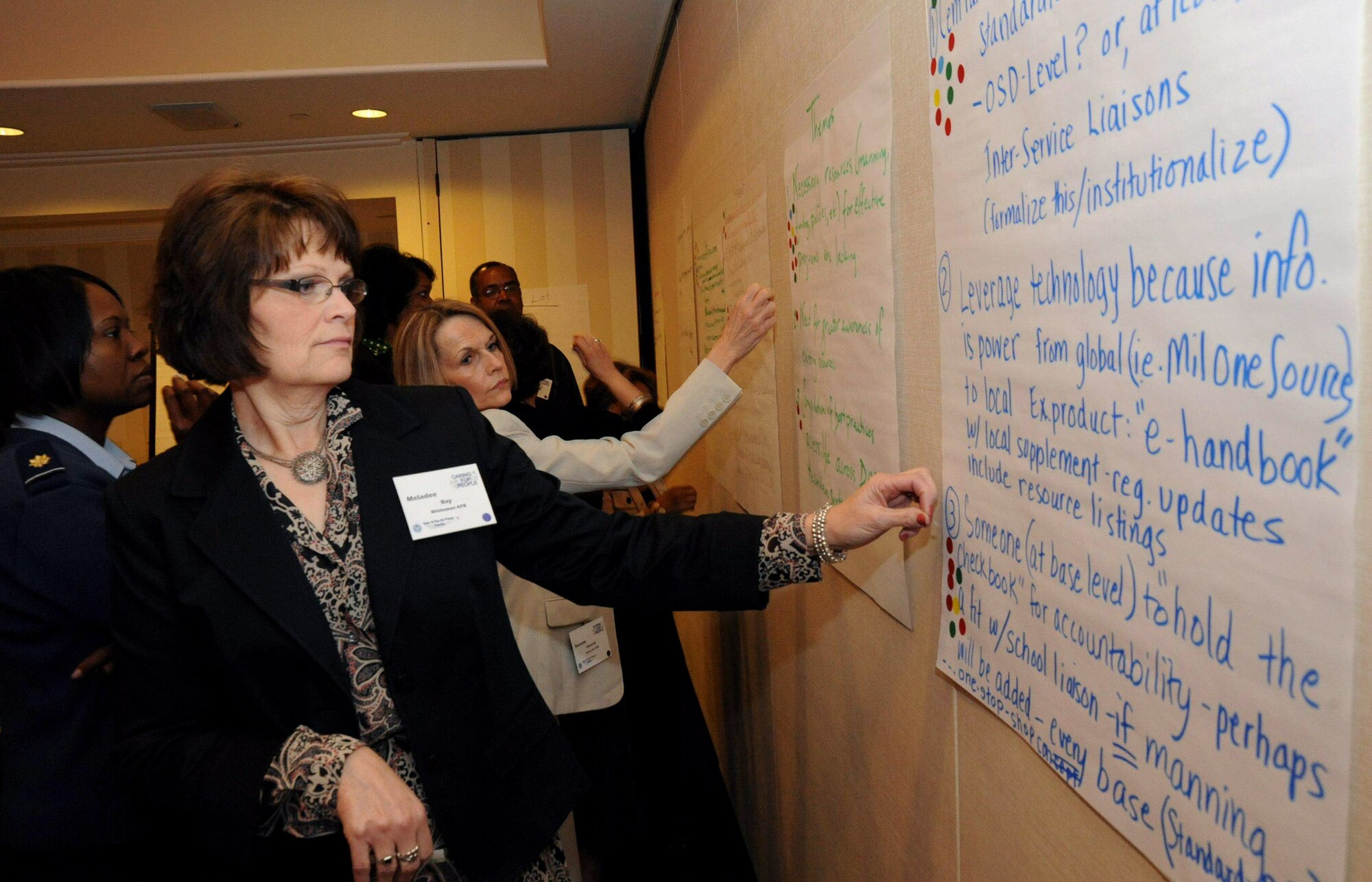 Meladee Bay votes on themes during a working group session at the Year of the Air Force Family: Caring for People Forum April 1 in Arlington, Va. The 25-person group developed themes and will use the best to develop initiatives focusing on special-needs children. Mrs. Bay is the chief of the Airman and Family Support Flight at Whiteman Air Force Base, Mo. (U.S. Air Force photo/Staff Sgt. Patrick Brown) 
