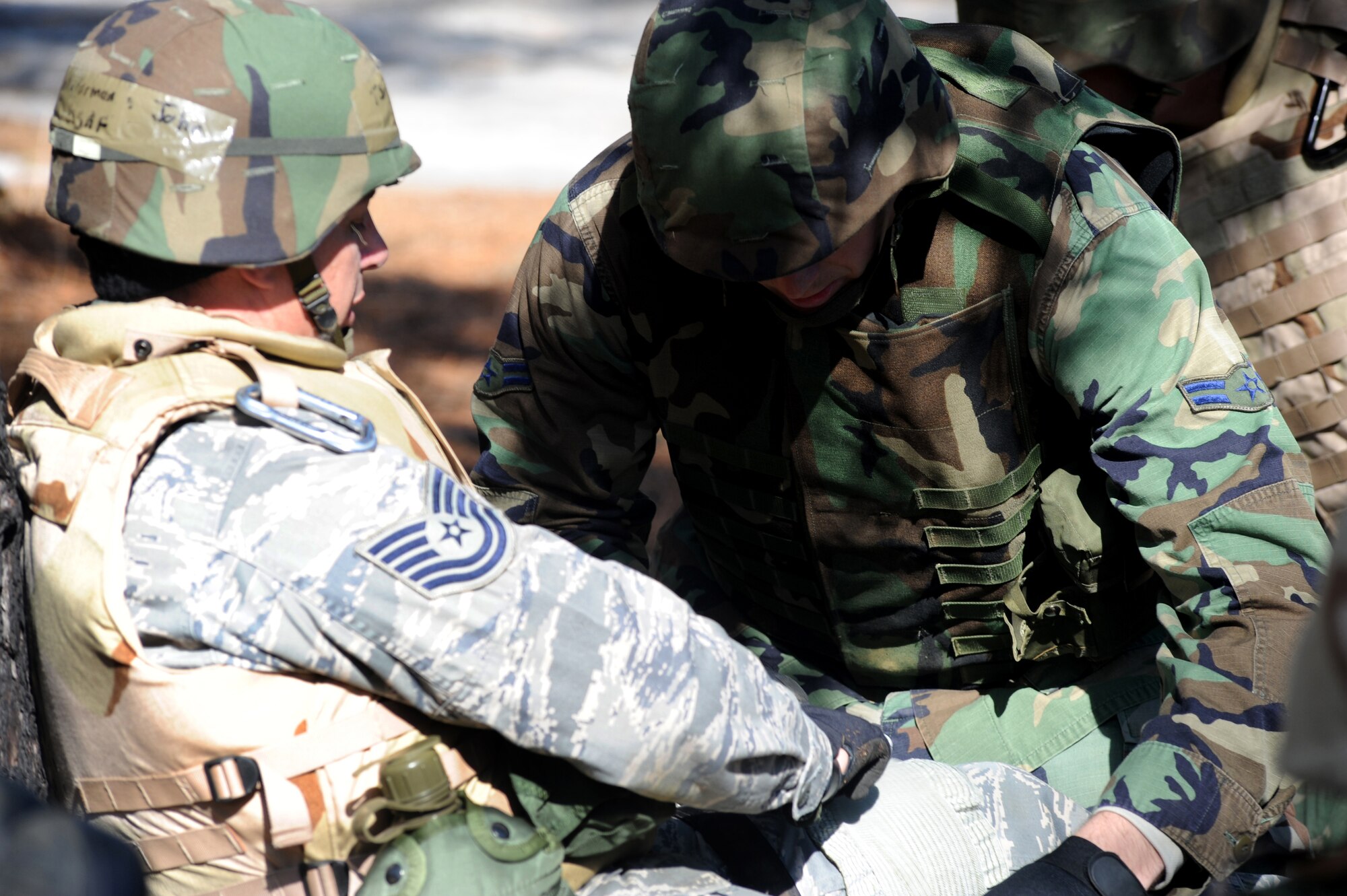 An Airman applies bandages to another Airman's leg during combat first aid training on a Fort Dix, N.J. range, March 31, 2009.  The students are in a U.S. Air Force Expeditionary Center's Advanced Contingency Skills Training Course taught by the 421st Combat Training Squadron which prepares Airmen for upcoming deployments with advanced combat skills.   (U.S. Air Force Photo/Staff Sgt. Nathan G. Bevier) 