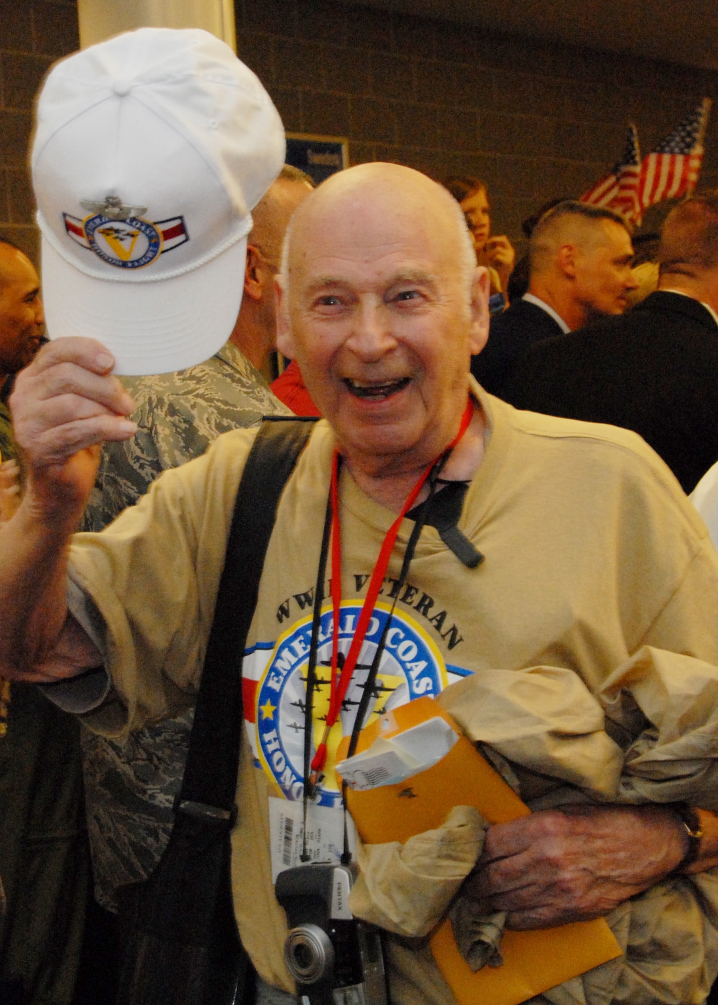 An excited veteran greets the room of well-wishers upon returning from the 3rd annual Honor Flight April 1.  The veterans left Florida in the morning to spend the day in Washington and visit the World War II memorial before returning to a hero’s welcome.  More than 200 military members lined the concourse to greet the veterans and their family as they exited.  Children and adults greeted them with flags and signs while bands played.  U.S. Air Force photo/ Samuel King Jr.
