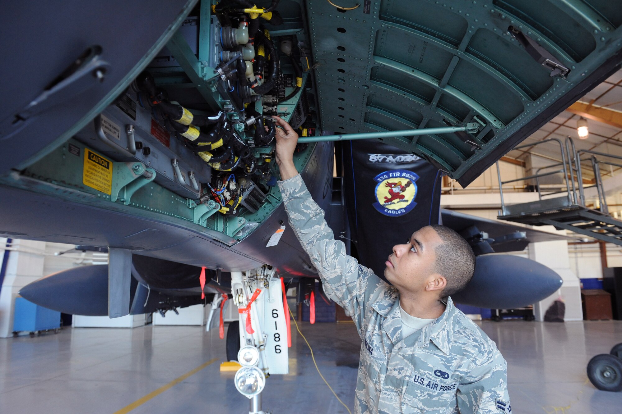 Airman 1st Class Julian Molina, 4th Component Maintenance Squadron, checks the electrical system on an F-15E Strike Eagle at Seymour Johnson Air Force Base, N.C., March 30, 2009. Airman Molina performs a visual inspection of circuit breakers to ensure reliable operation in the fuels system hangar. (U.S. Air Force photo by Airman 1st Class Whitney S. Lambert)