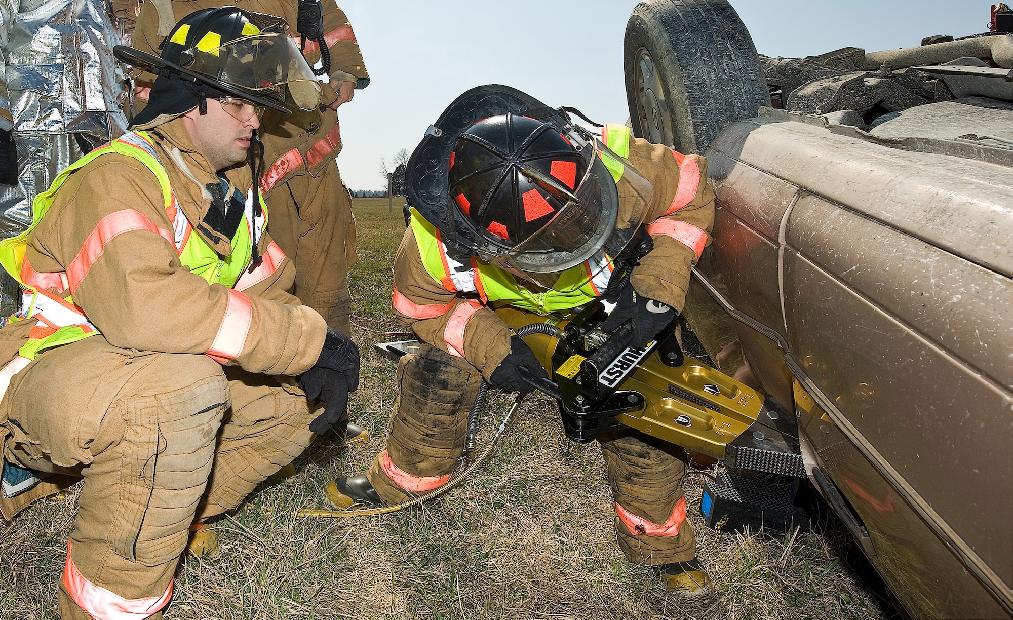 Airman 1st Class James Bullock, 436th Civil Engineer Squadron firefighter, watches as another firefighter uses the "jaws of life" to open a car door during an auto extrication exercise March 18. (U.S. Air Force photo/ Roland Balik)