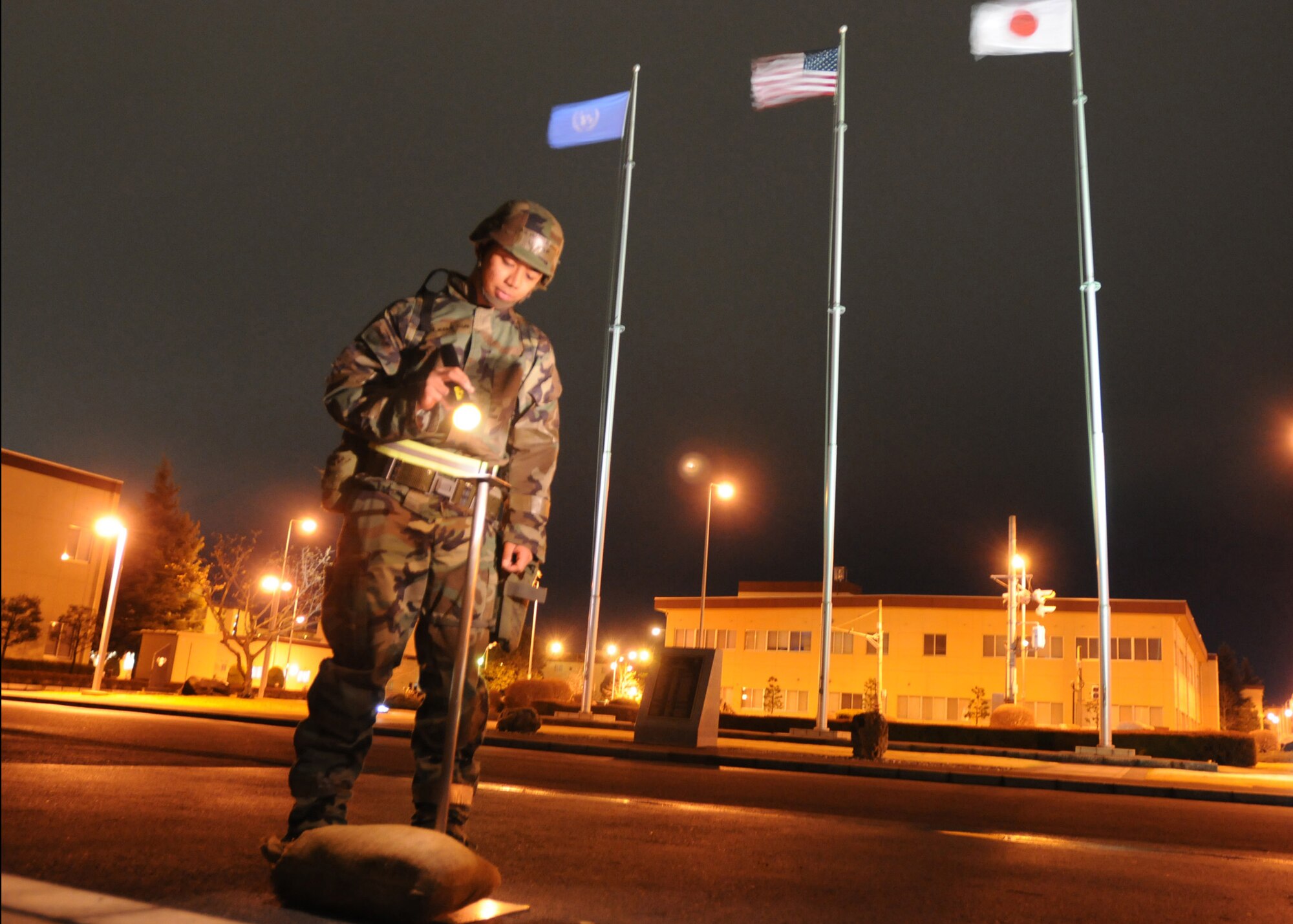 YOKOTA AIR BASE, Japan -- Senior Airman Mario Marquez from the 374th AW examines an M8 stand  to ensure the equipment is in proper order despite high winds Wednesday night. Yokota is conducting a phase I and II exercise March 30 through April 3 to maintain operational readiness. (U.S. Air Force photo/ Senior Airman Veronica Pierce)


