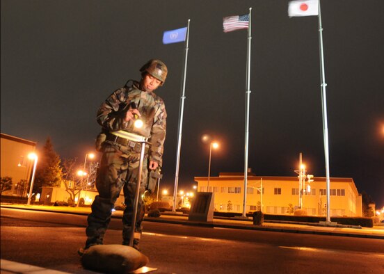 Senior Airman Mario Marquez, 374th Airlift Wing, examines an M-8 stand to ensure the equipment is in proper order despite high winds April 1 at Yokota Air Base, Japan. Base personnel are conducting a phase I and II exercise March 30 through April 3 to maintain operational readiness. (U.S. Air Force photo/Senior Airman Veronica Pierce) 