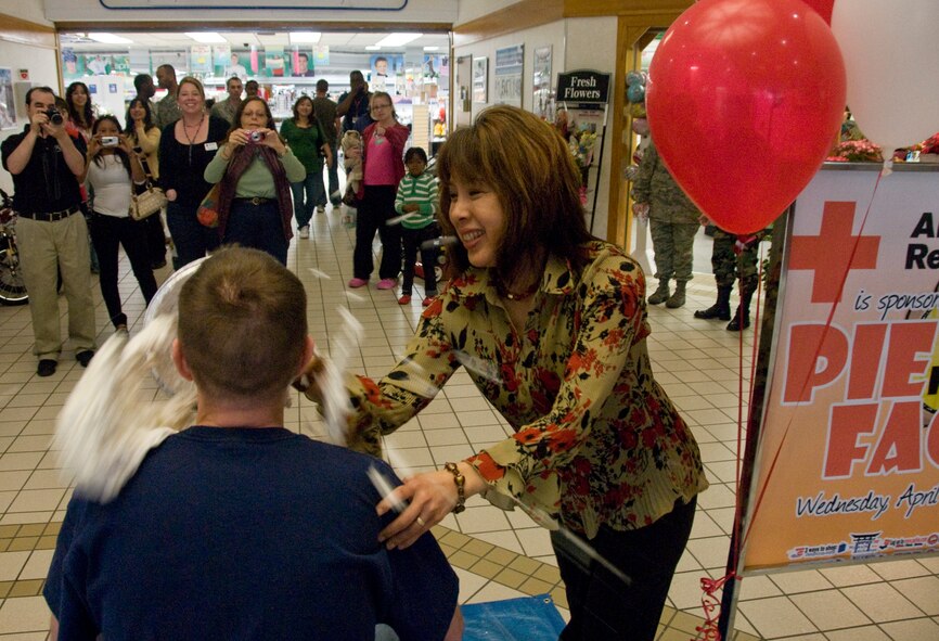 MISAWA AIR BASE, Japan -- Jan Stilwell, wife of 35th Fighter Wing commander, Col. David Stilwell, smashes a pie in the face of Master Sgt. Eric McCammond, 35th Force Support Squadron first sergeant, April 1, 2009. Mrs. Stilwell was the highest bidder in a crowd of people in front of the base exchange and won the honor of throwing the pie. (U.S. Air Force photo by Staff Sgt. Araceli Alarcon)