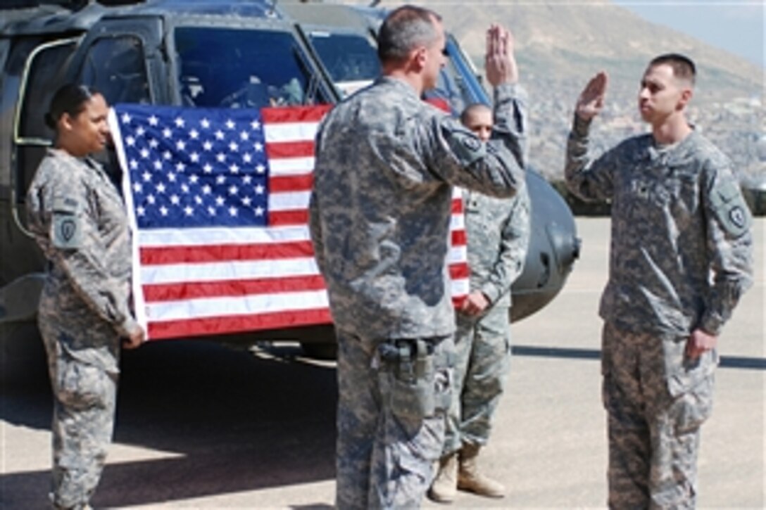 U.S. Army Spc. Patrick Horton recites the enlistment oath with Brig. Gen. Robert Brown during his re-enlistment ceremony in Dohuk, Iraq, March 21, 2009. Horton's re-enlistment was held in front of members of the 25th Infantry Division and members of the Kurdish Democratic Party.