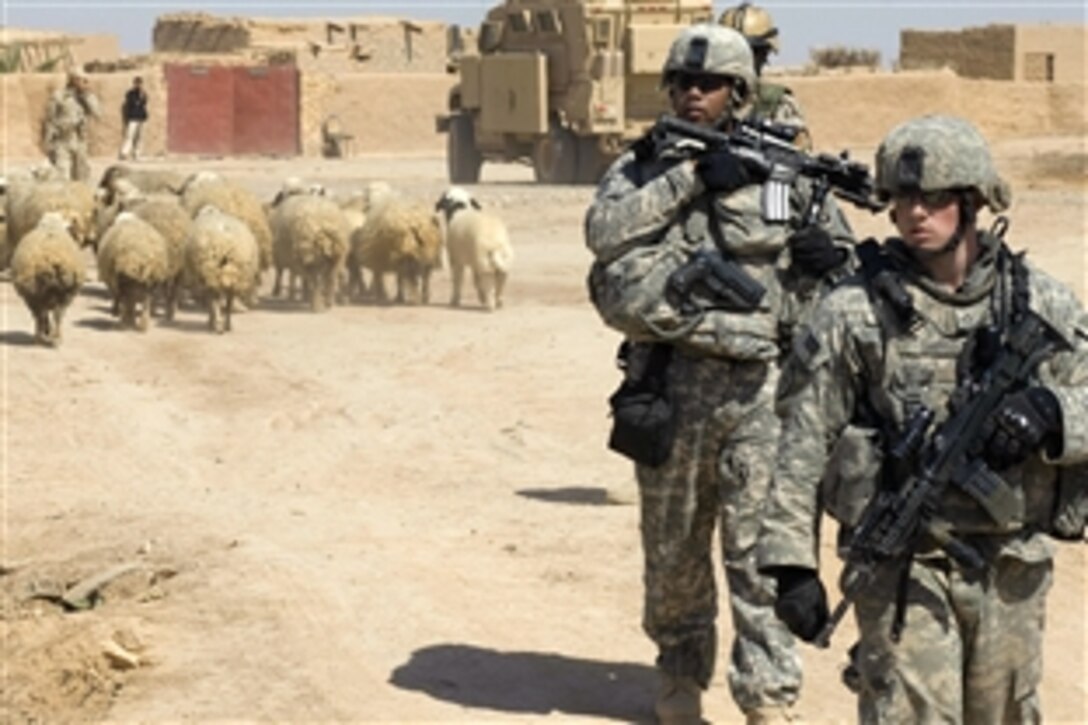 U.S. Army soldiers provide security while Iraq army soldiers provide humanitarian aid to villagers in Shuzayf, Iraq, March 27, 2009. The soldiers are assigned to the 25th Infantry Division's 1st Battalion, 24th Infantry Regiment, 1st Stryker Brigade Combat Team.
