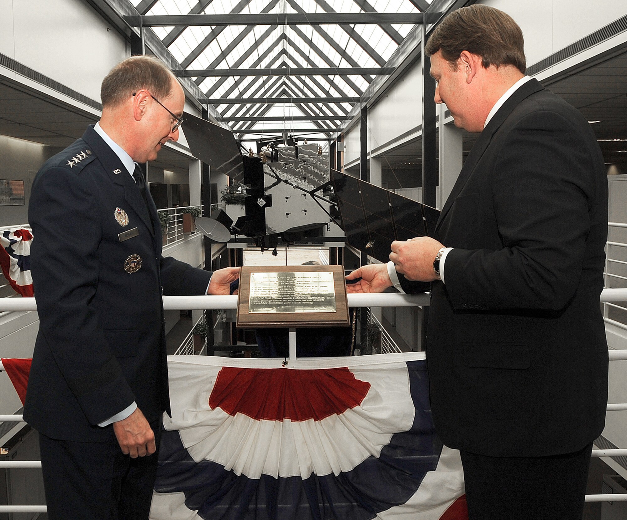 Gen. C. Robert Kehler, commander of Air Force Space Command, and Mr. Kevin Bilger, vice president and general manager of Global Communications Systems at Lockheed Martin, unveil the plaque describing the new Advanced Extremely High Frequency satellite model. The one-quarter scale model was donated to AFSPC April 1 by Mr. Bilger on behalf of Lockheed Martin. The first AEHF satellite is scheduled to be launched the last quarter of 2010. (U.S. Air Force photo/Tech. Sgt. Matt Lohr) 
