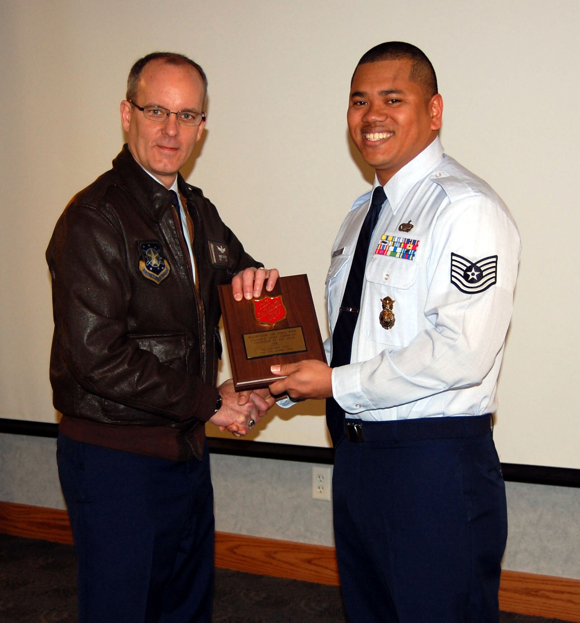 Col. Michael Fortney, 341st Missile Wing commander, receives the Salvation Army's Corporate Volunteer of the Year award from Tech. Sgt. Kenneth Hilliard, 741st Missile Security Forces Squadron March 23. Sergeant Hilliard represented the wing at the Salvation Army's awards ceremony recently. Malmstrom personnel volunteered more than 920 hours and provided 464 volunteers to Salvation Army fundraisers, community events and programs in 2008. (U.S. Air Force photo/Staff Sgt. Eydie Sakura)