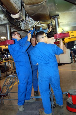 Col. Paul Gydesen (left), 341st Missile Wing vice commander, works at loosening a bolt on a cracked transfer casing at the 341st Logistics Readiness Squadron vehicle maintenance bay March 26. Airman 1st Class Bruce Rivera and Bob Cecerle assisted the vice commander wtih the project. (U.S. Air Force photo/Valerie Mullett)
