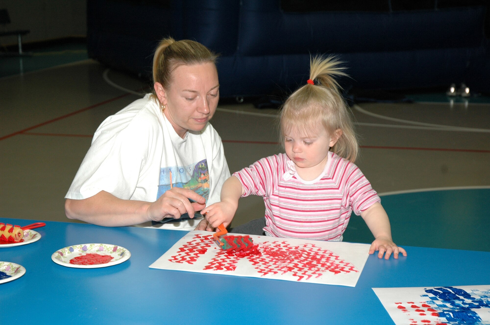 Little Warrior Eleny, 2, and her mom Nicola, paint at the arts and crafts table during the Youth Programs Center's Month of the Military Child spring carnival celebration last year. This year's spring carnival is April 11 from 11 a.m. to 1 p.m. Wristbands for unlimited play are on sale now at the Youth Center and cost $5. (U.S. Air Force photo/Airman 1st Class Emerald Ralston)