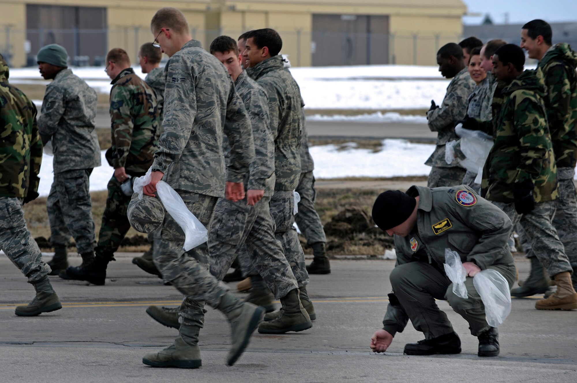Capt. Dan Kunkel, 37th Bomb Squadron safety officer, collects a piece of foreign object debris here, April 3. FOD walks are performed to clean the flight line of debris that can damage or disable aircraft. (U.S. Air Force photo/Senior Airman Marc I. Lane)
