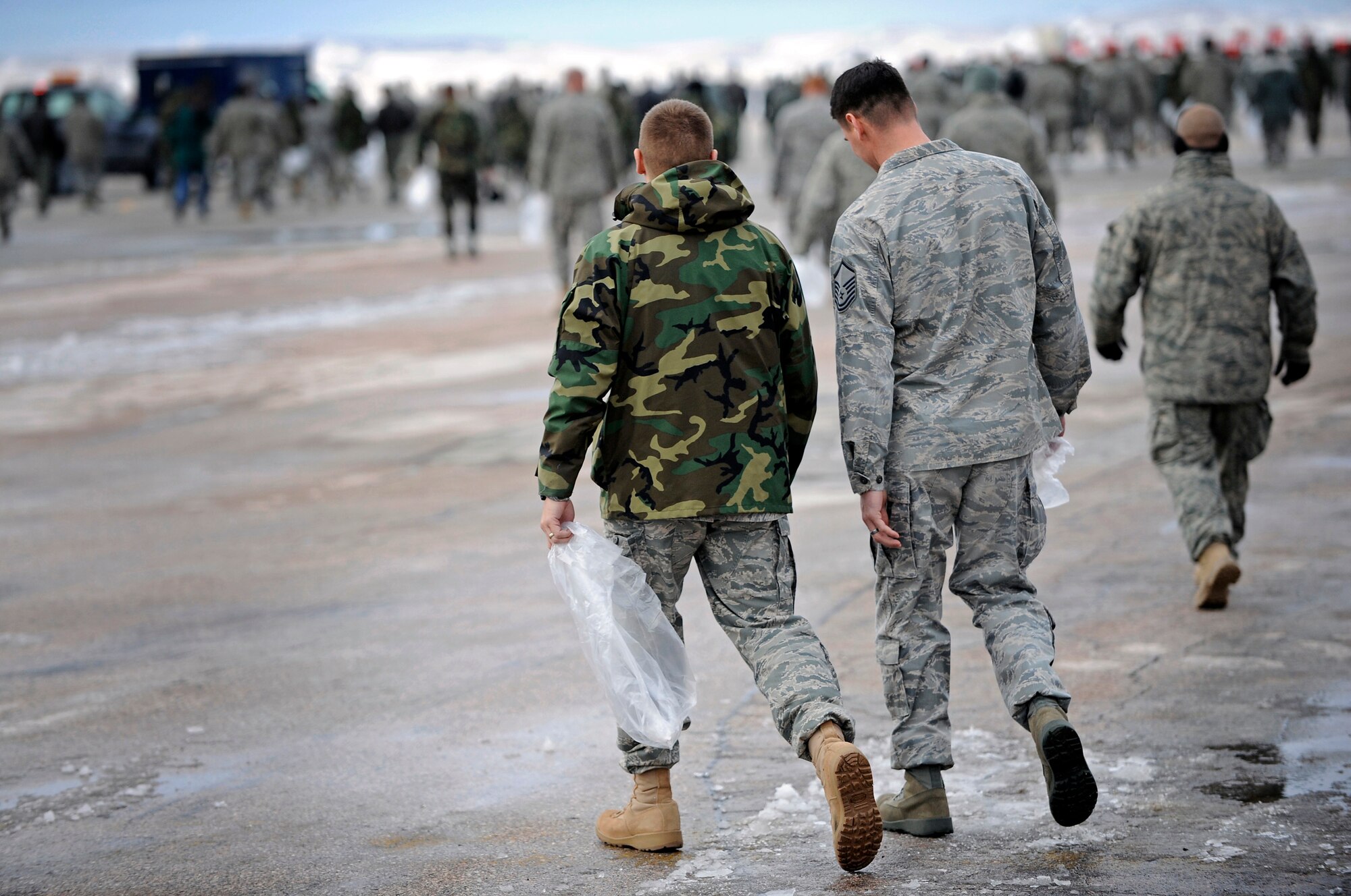 Members of the 28th Bomb Wing walk the flight line searching for foreign object debris here, April 3. Foreign object debris is a substance, debris or article alien to the vehicle or system which would potentially cause damage. (U.S. Air Force photo/Senior Airman Marc I. Lane)